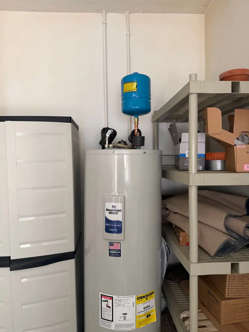 Tank water heater with an expansion tank in a garage utility closet