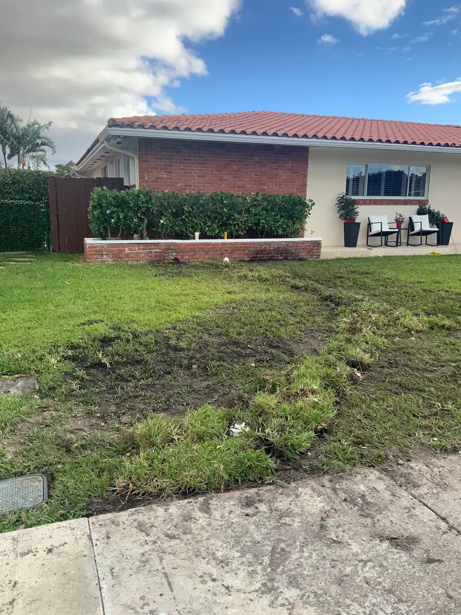 A Miami ranch house with a red barrel-tile roof after an Authentic Plumbing Services line repair across the front lawn