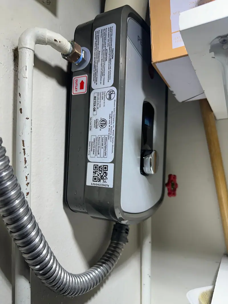 Tankless electric water heater installed in a closet