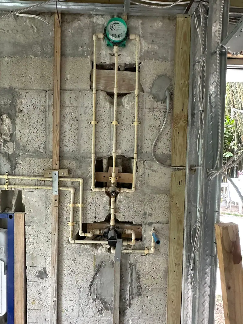 Copper and brass water lines with valves in a block-wall pipe chase