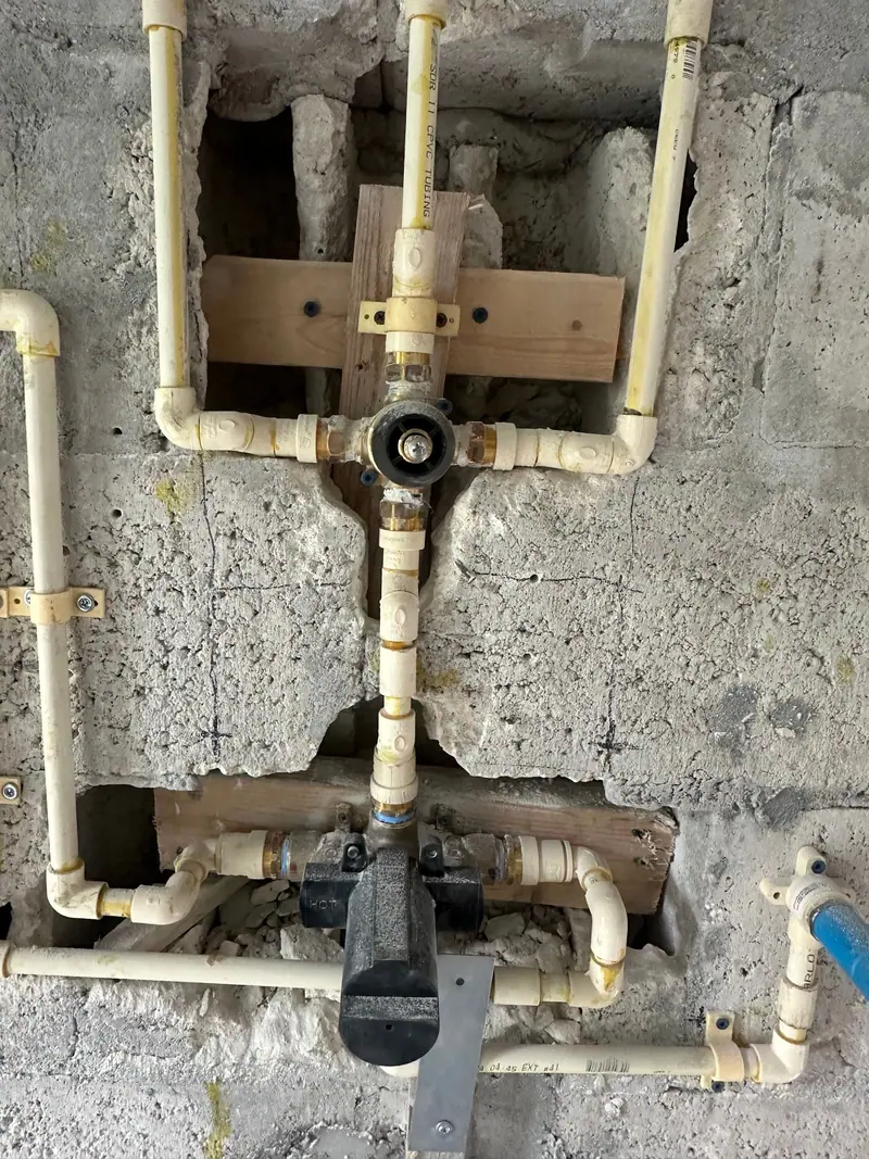 Shower valve rough-in plumbing set in an opening in a block wall