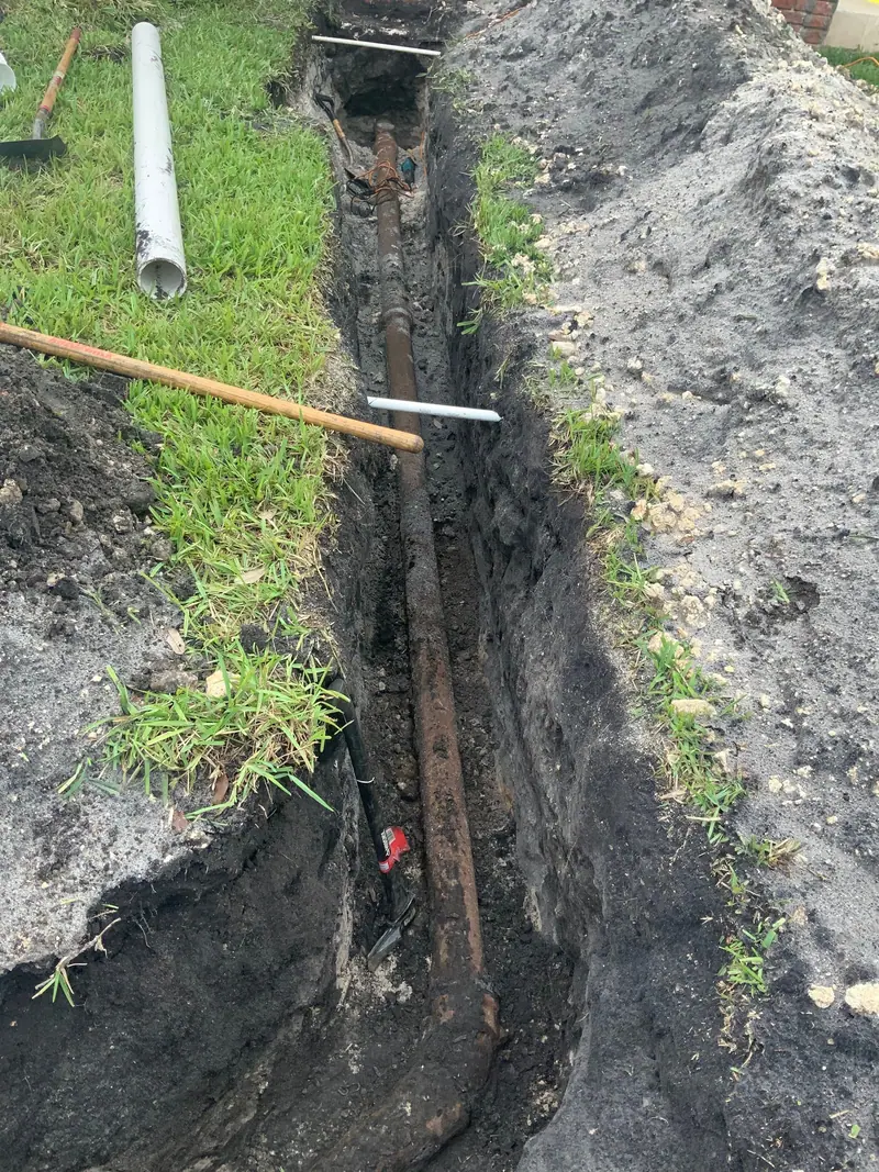 Trench along a house exposing the old line before replacement
